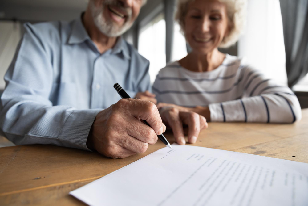 pareja de adultos mayores firmando contrato